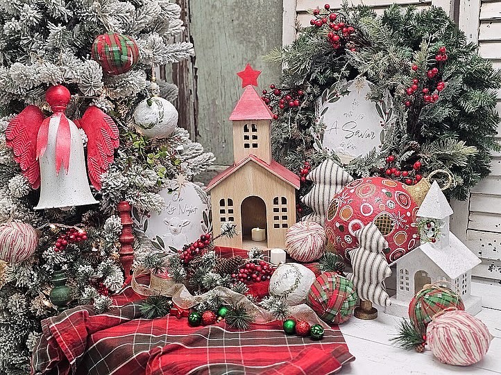 Christmas decor with miniature houses, ornaments, and frosted wreath.