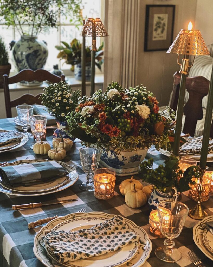 Thanksgiving table with floral centerpiece candles and pumpkins