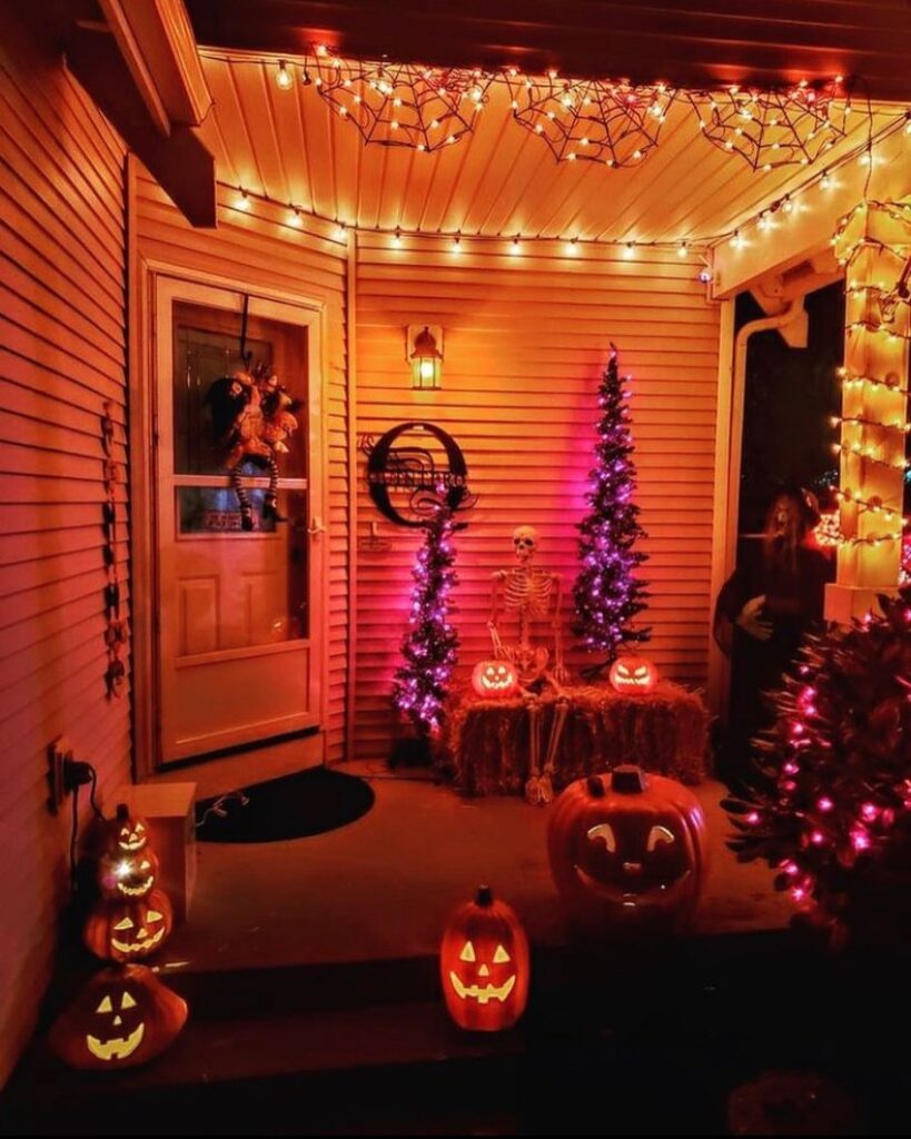 Festively lit Halloween porch with skeleton