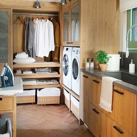 Wooden laundry room with built-in closet washer dryer and terra cotta floor.