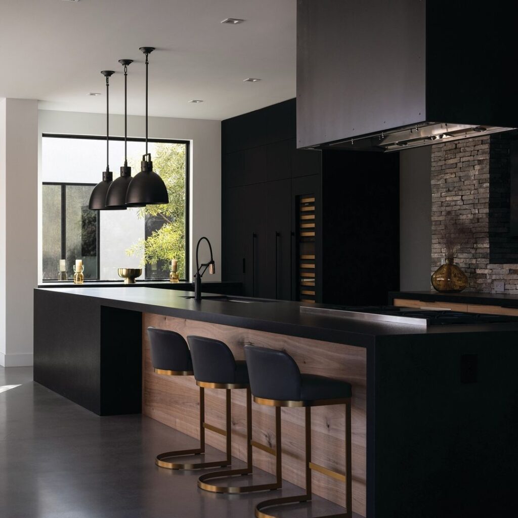 Modern black kitchen with wooden island and gold-based stools