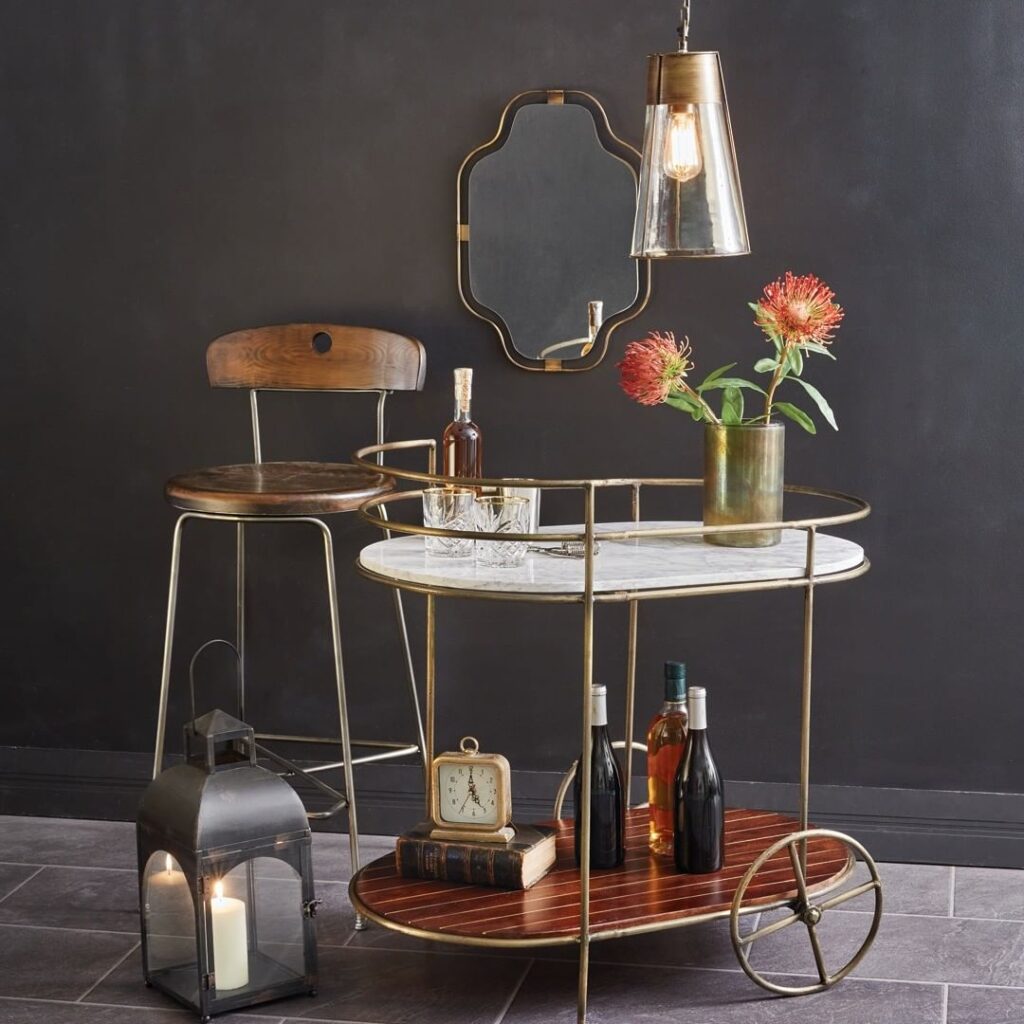 Stylish bar cart with pendant light mirror and decor.