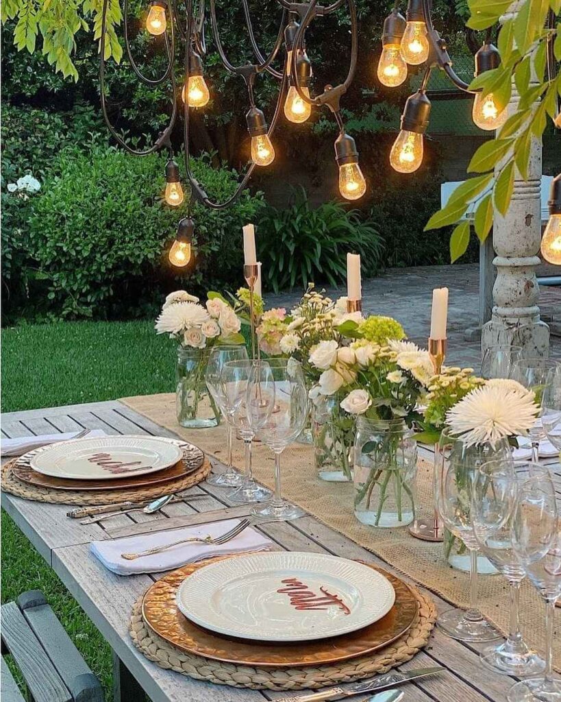 Outdoor Thanksgiving table with hanging lights and floral centerpieces