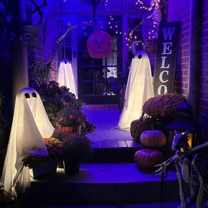 Purple-lit porch with glowing ghost decorations and pumpkins