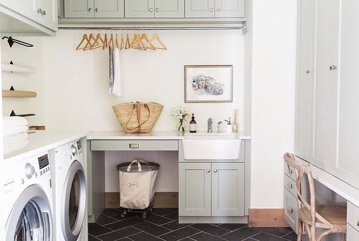 Bright laundry room with gray cabinets and farmhouse sink.