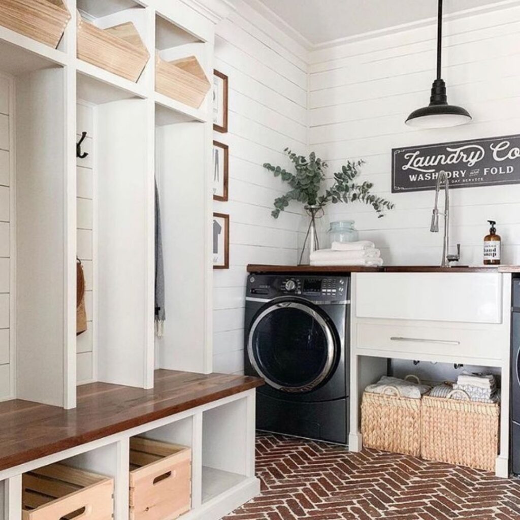 Farmhouse-style laundry room with shiplap walls and brick floor