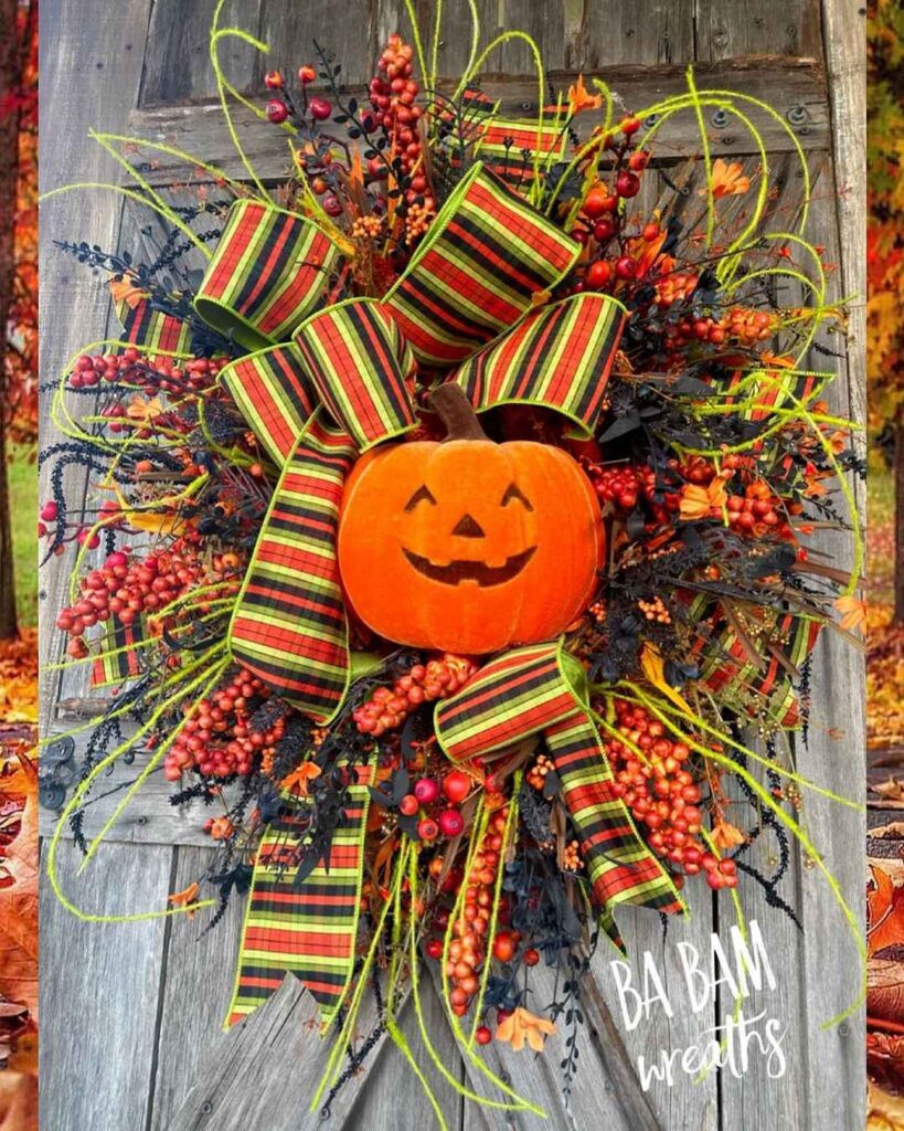 Halloween wreath with jack-o-lantern and colorful fall decorations.