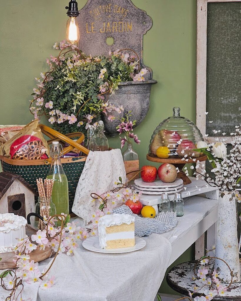 Vintage garden-themed tea party setup with flowers, cakes, and French decor.