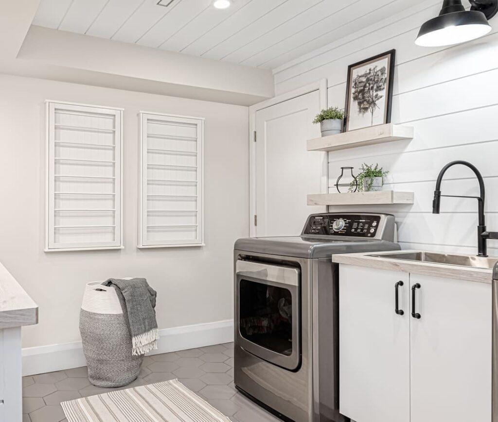 White farmhouse laundry room with modern appliances and rustic touches.