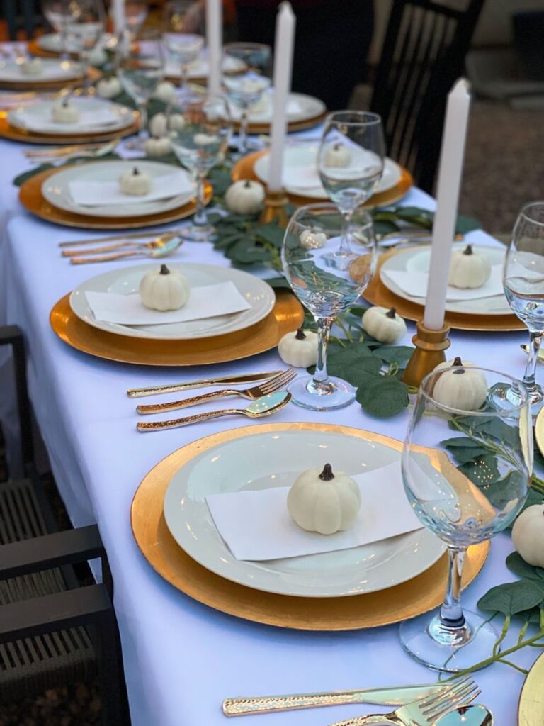 Elegant Thanksgiving table with gold plates and white pumpkins