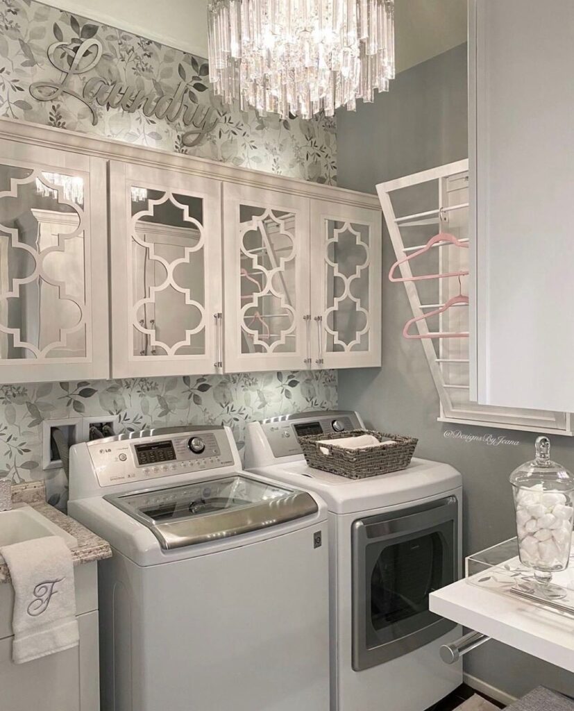 Luxurious laundry room with chandelier and decorative cabinets.