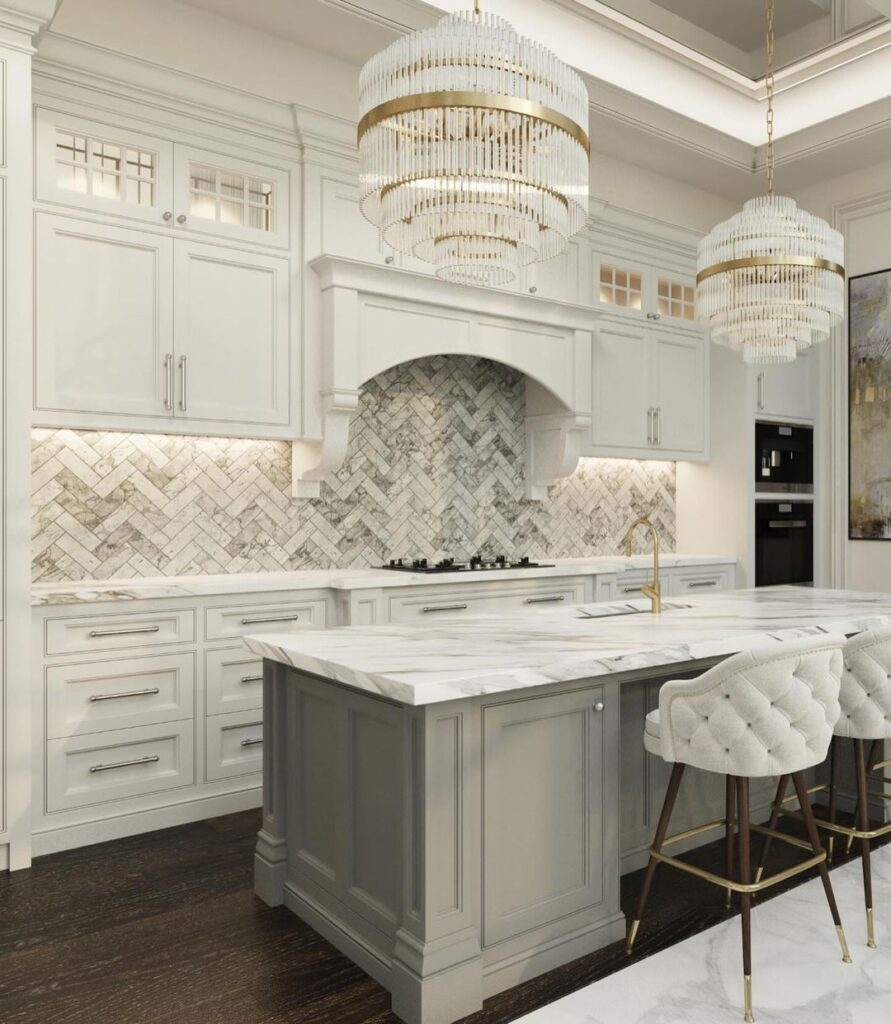 Luxurious white kitchen featuring crystal chandeliers and marble island