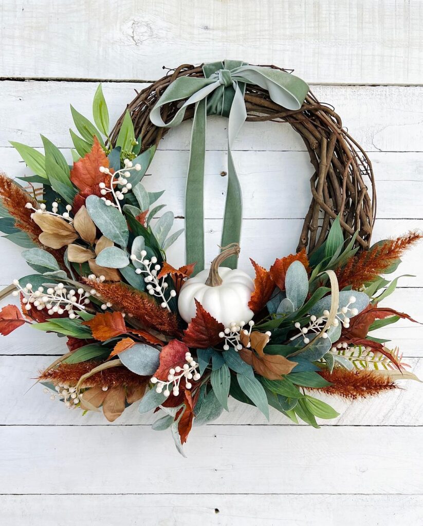 Autumn wreath with white pumpkin and colorful leaves