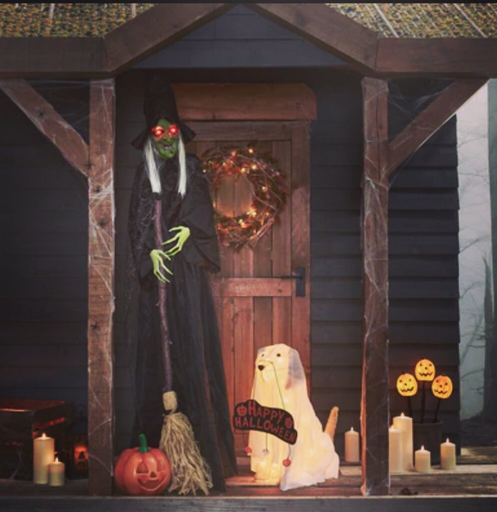 Elegant haunted porch with witch and decorations.