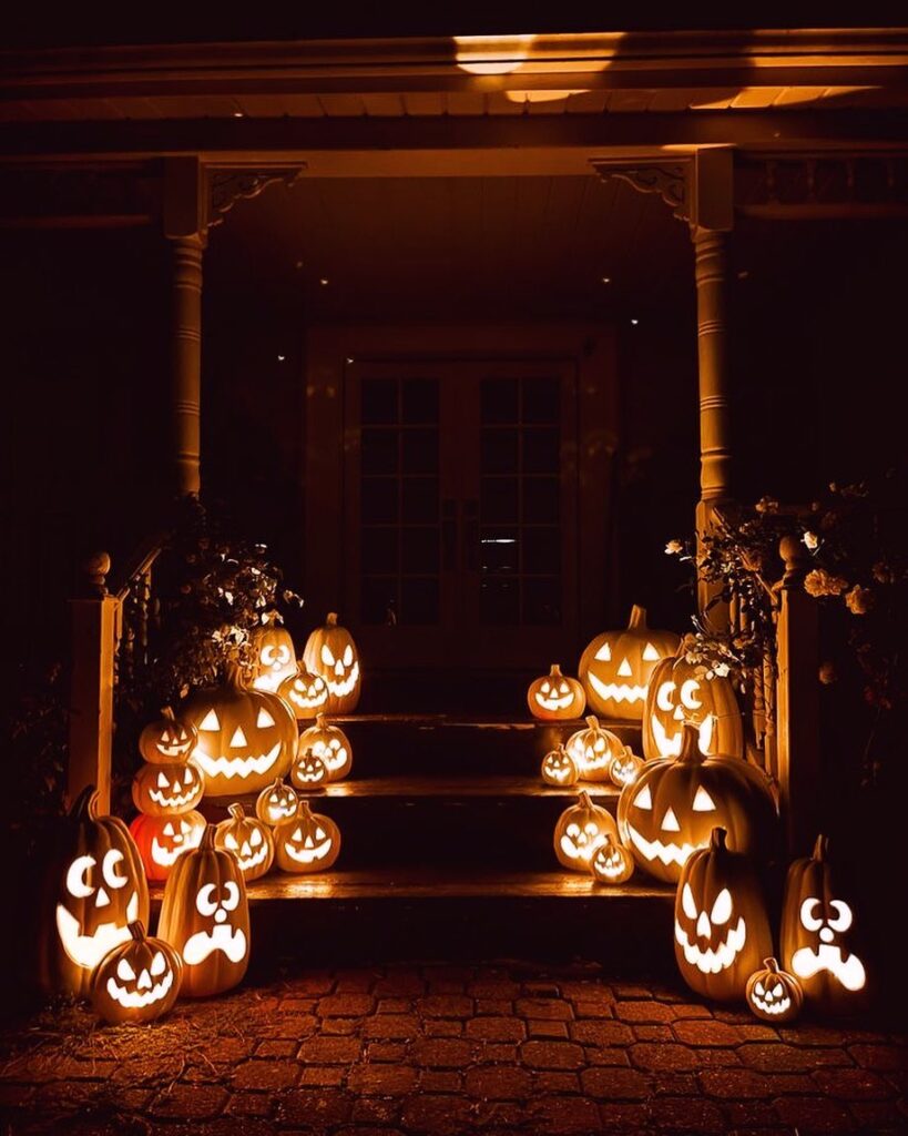 Glowing jack-o'-lanterns lining porch steps entrance