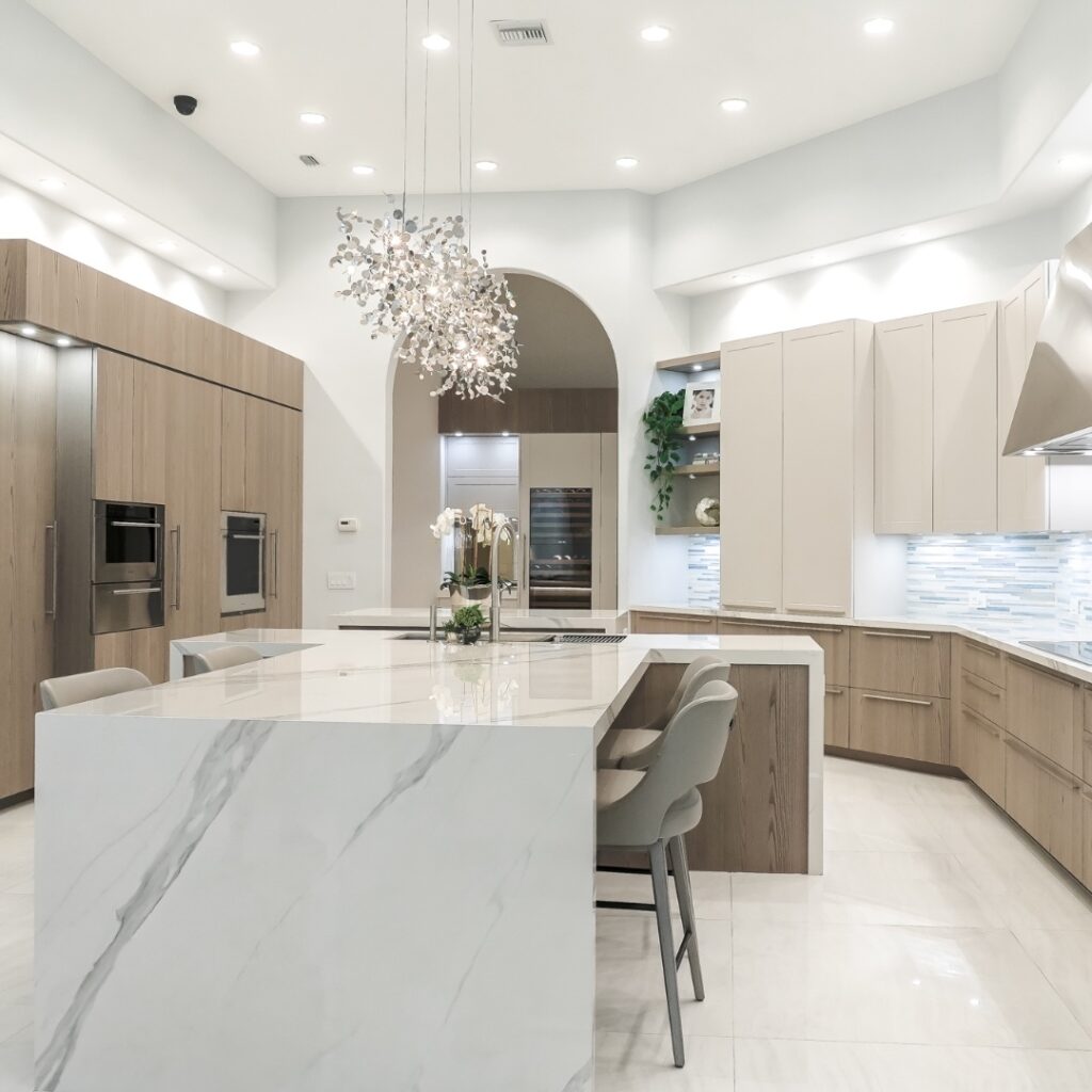 Bright kitchen with marble island and crystal chandelier