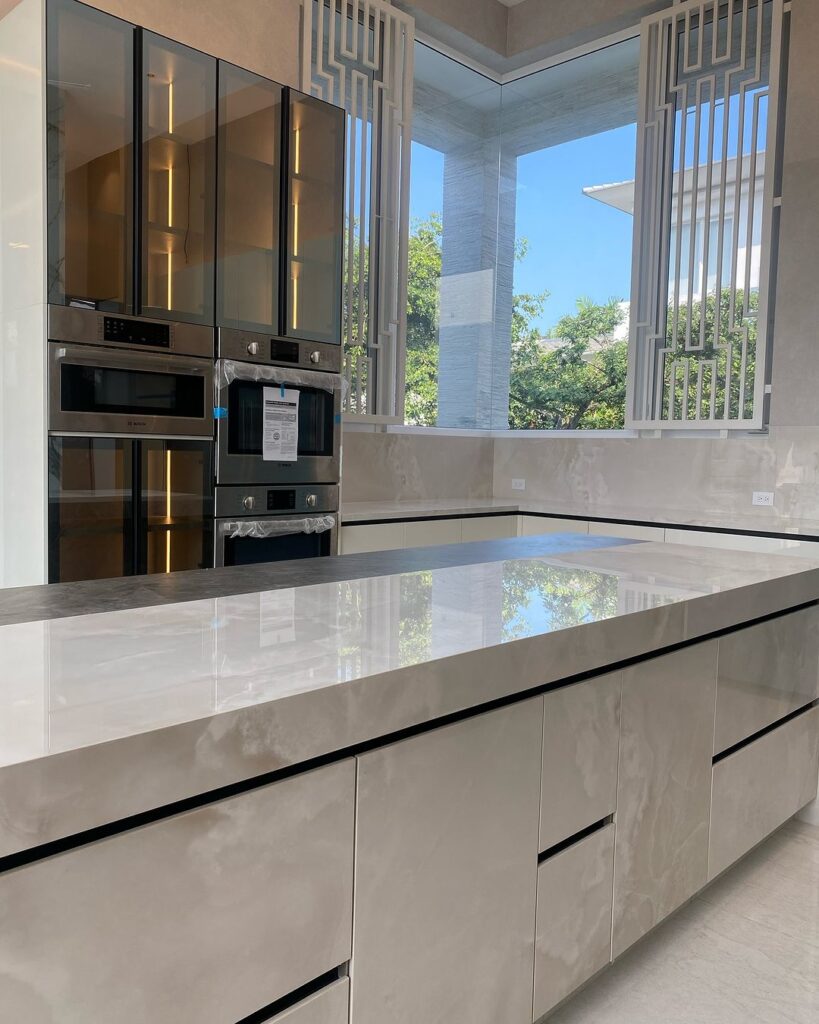 Sleek white kitchen featuring corner windows and decorative grillwork