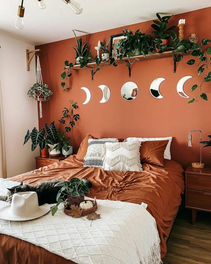 Boho bedroom with terracotta walls and moon mirrors