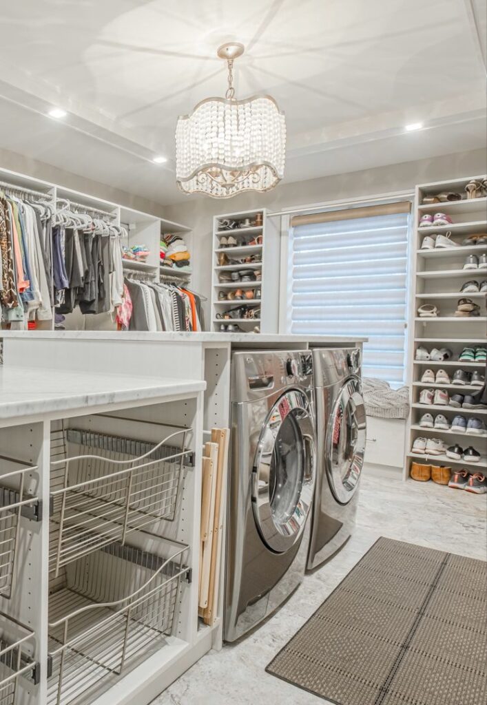 Elegant laundry room with chandelier closet space and modern appliances.