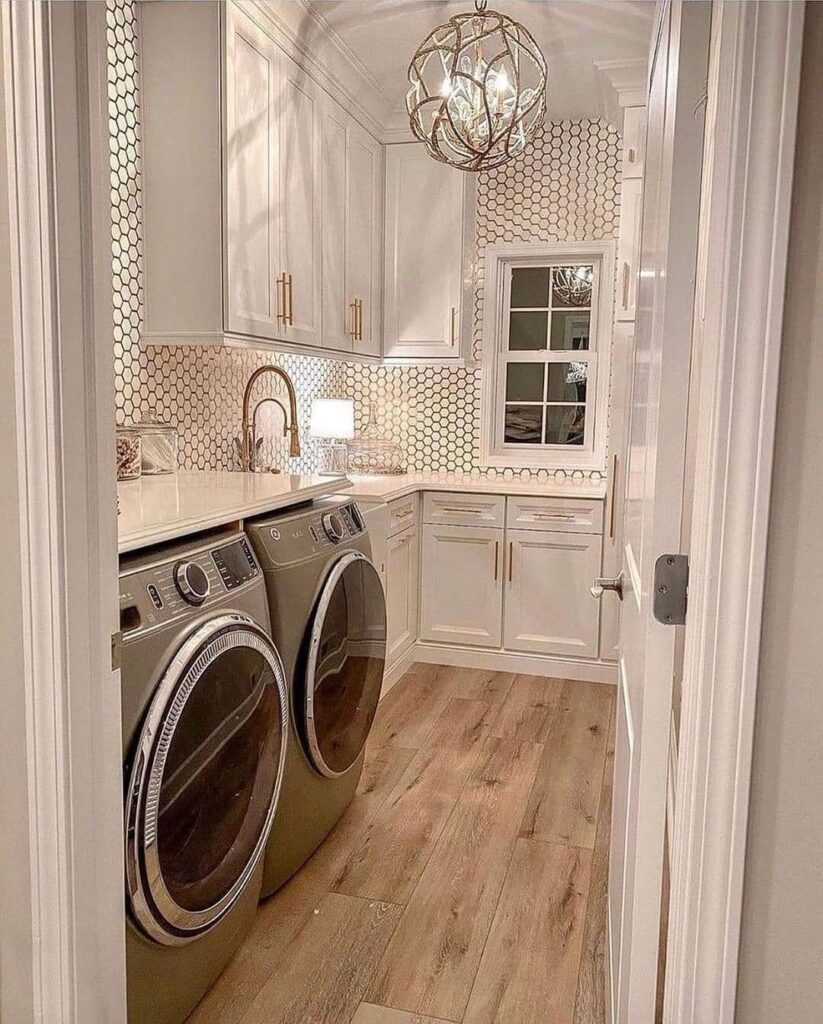 Upscale laundry room with chandelier and hexagon backsplash.