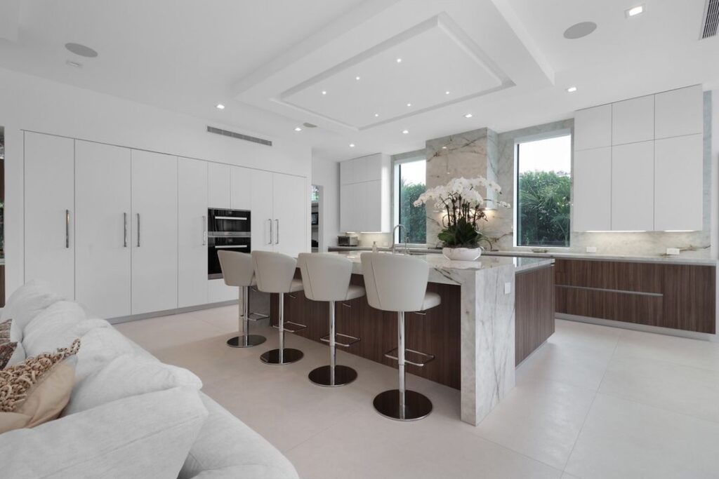 Modern white kitchen with marble island and wood accents