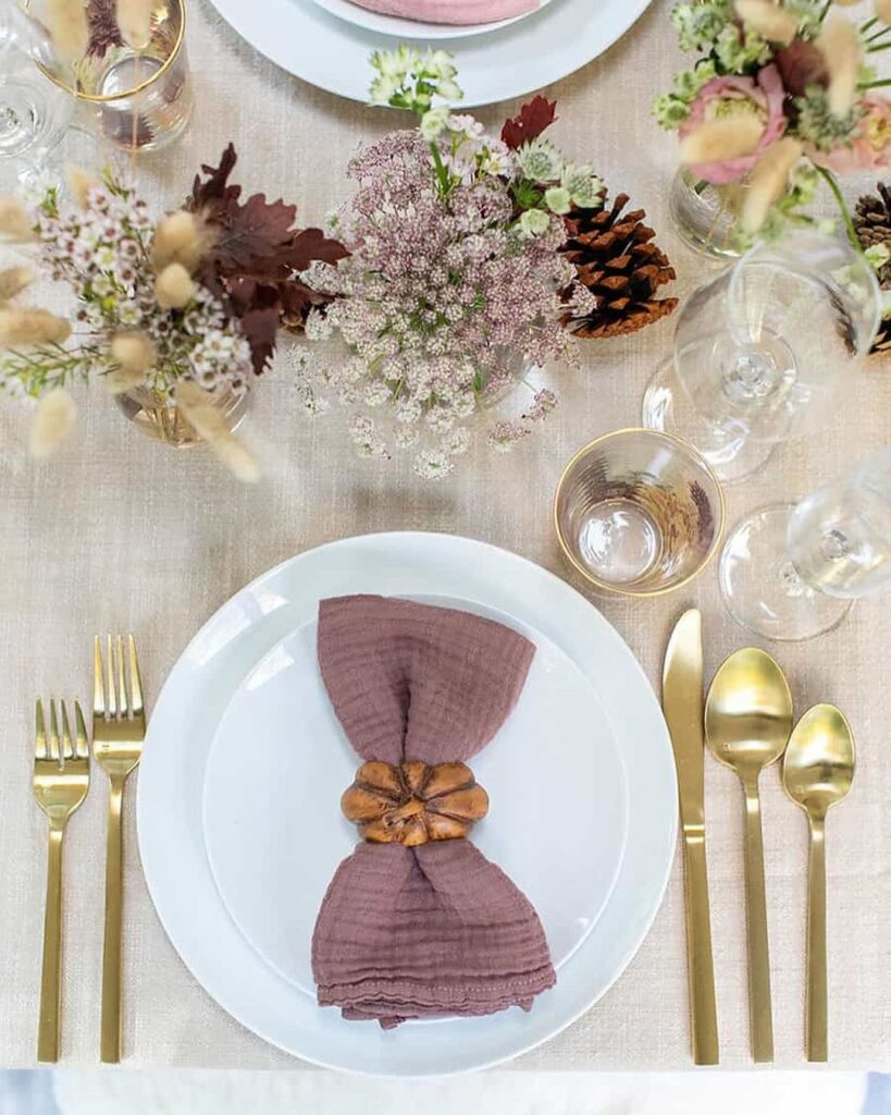 Thanksgiving table with mauve napkins and wildflower centerpiece