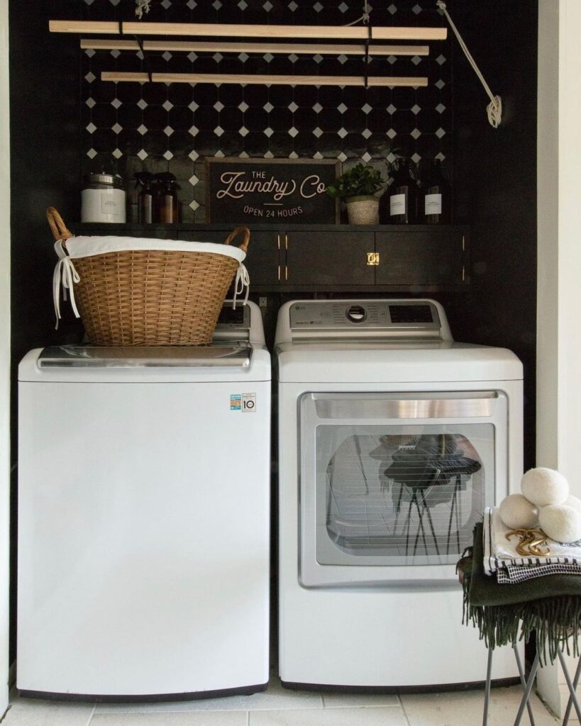 Stylish laundry nook with black walls and white appliances.