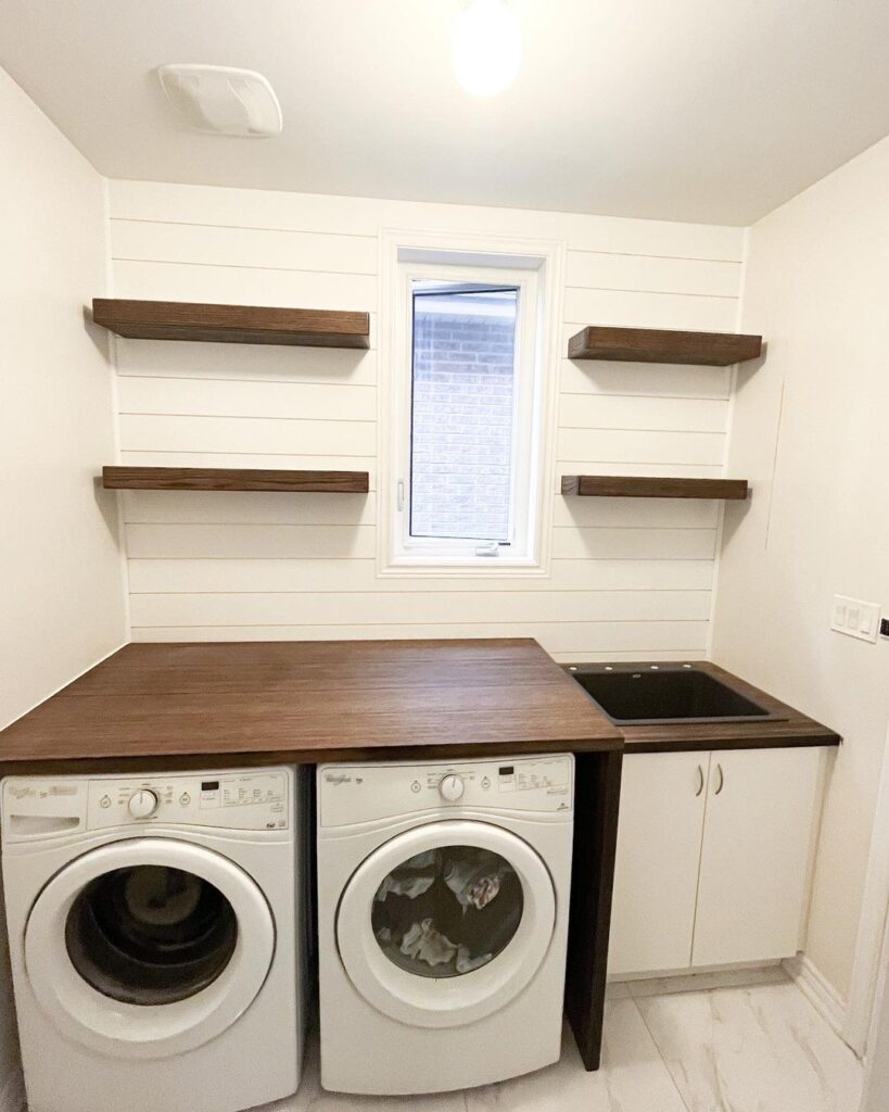 Laundry room with white appliances and wooden countertop