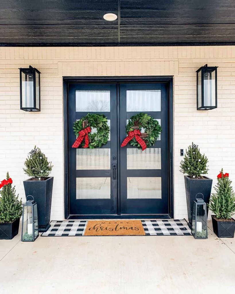 Modern black doors with Christmas wreaths and decorative trees