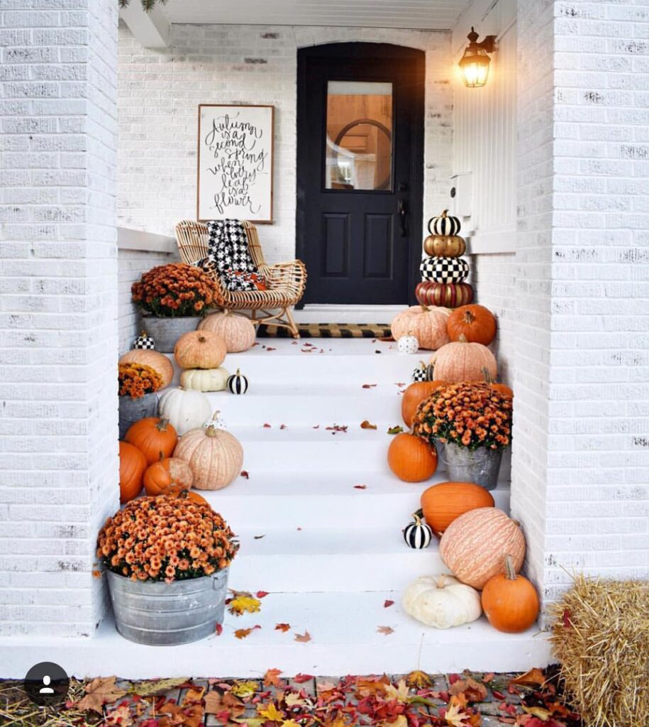 Modern farmhouse porch decorated with pumpkins and mums