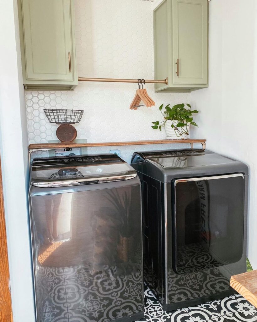 Laundry area with stainless appliances and sage cabinets