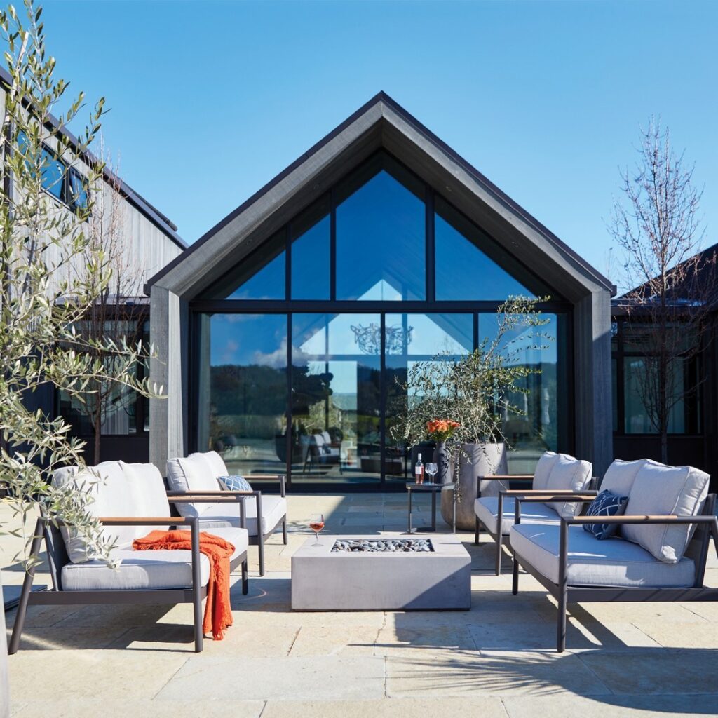 Modern patio furniture facing glass farmhouse facade