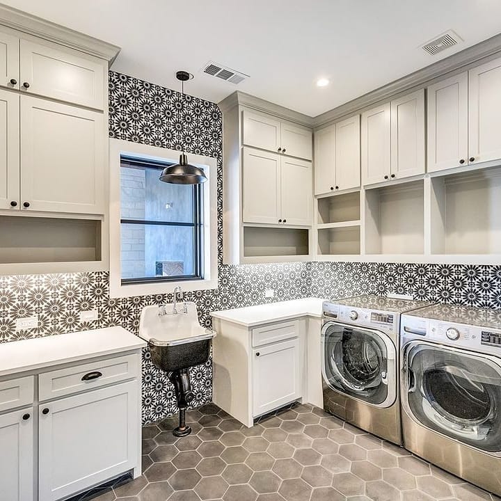 Modern laundry room with patterned tile backsplash.