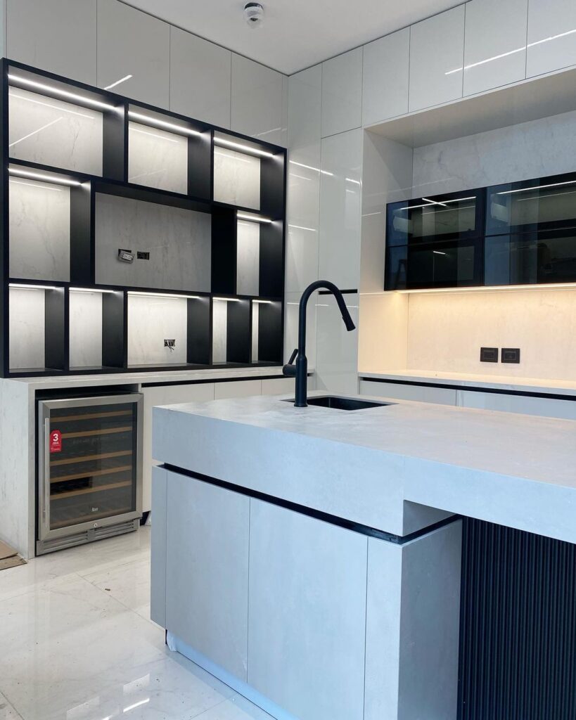 Modern black and white kitchen with illuminated grid-style cabinetry