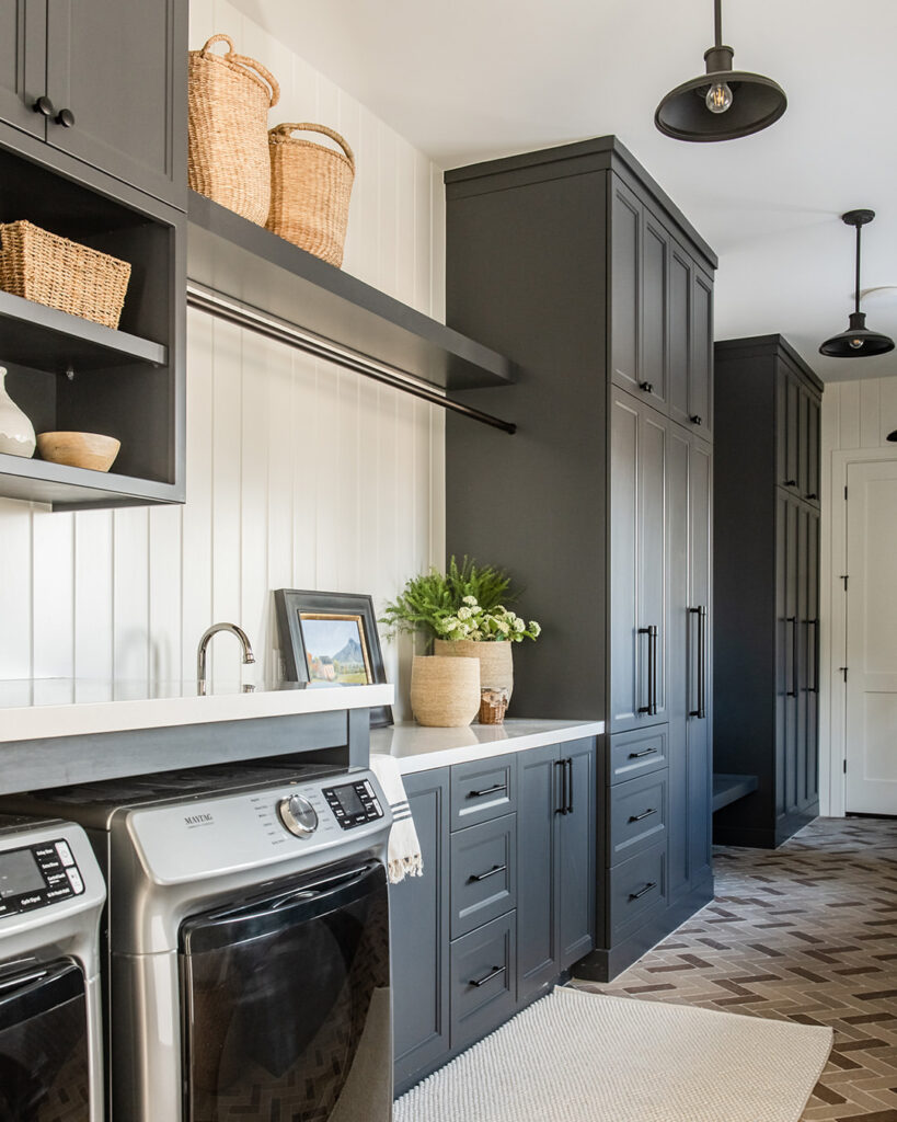 Dark gray laundry room with farmhouse touches and herringbone floor