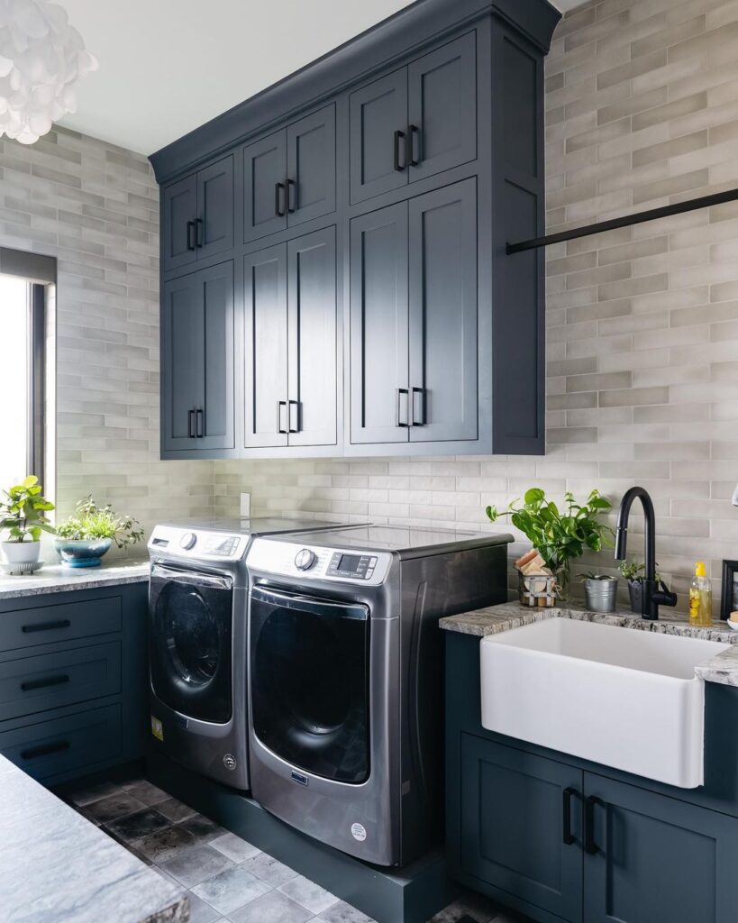 Laundry room with navy cabinets and modern appliances