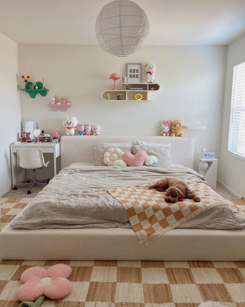 Cozy bedroom with white bed plush toys and pastel decor.