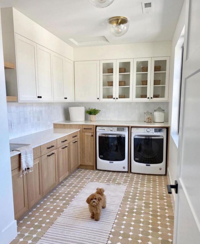 Bright laundry room with wood and white cabinets, dog on rug