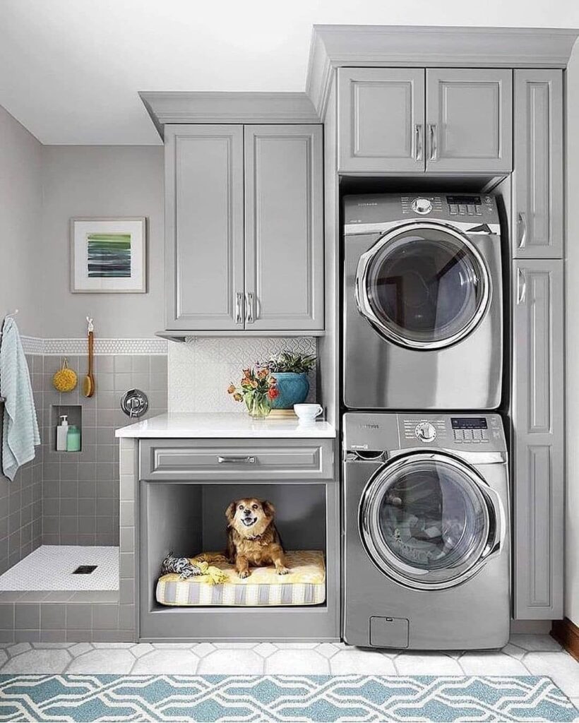 Laundry room with stacked washer dryer and dog bed