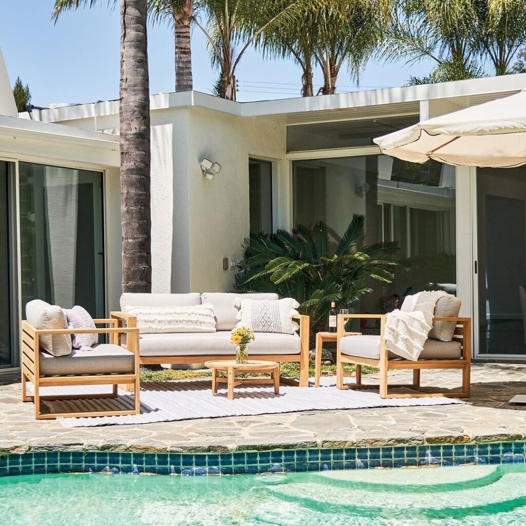 Teak patio furniture beside modern pool