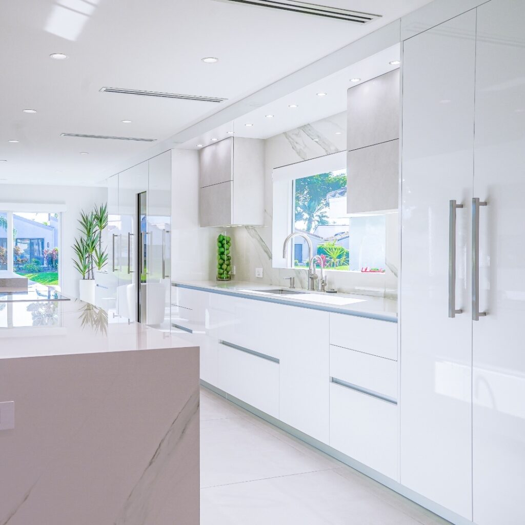 Bright white kitchen with garden view and green accents