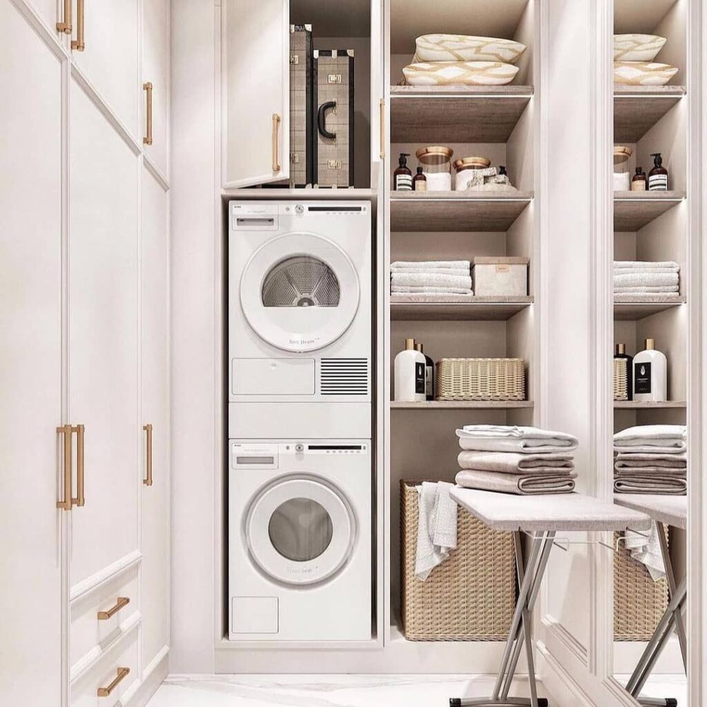 Minimalist white laundry nook with stacked washer-dryer and organized shelving.