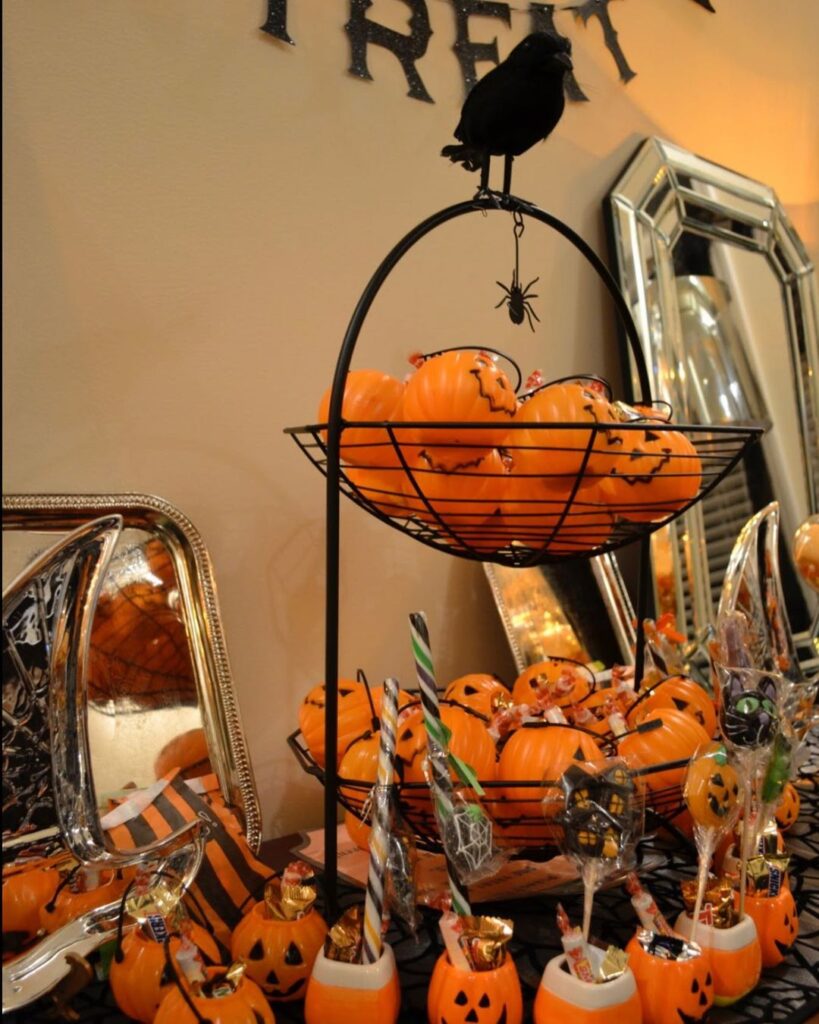 Elegant Halloween setup with pumpkin baskets and candy-filled decorations.