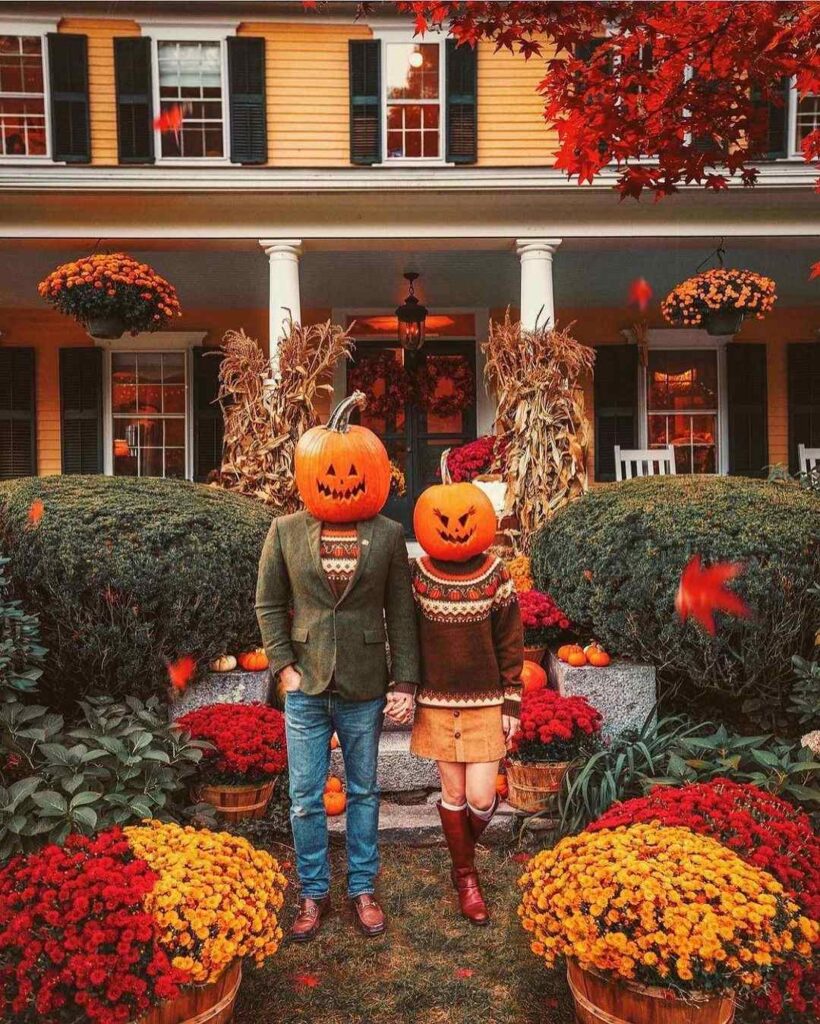 Couple with pumpkin heads amid fall decorations