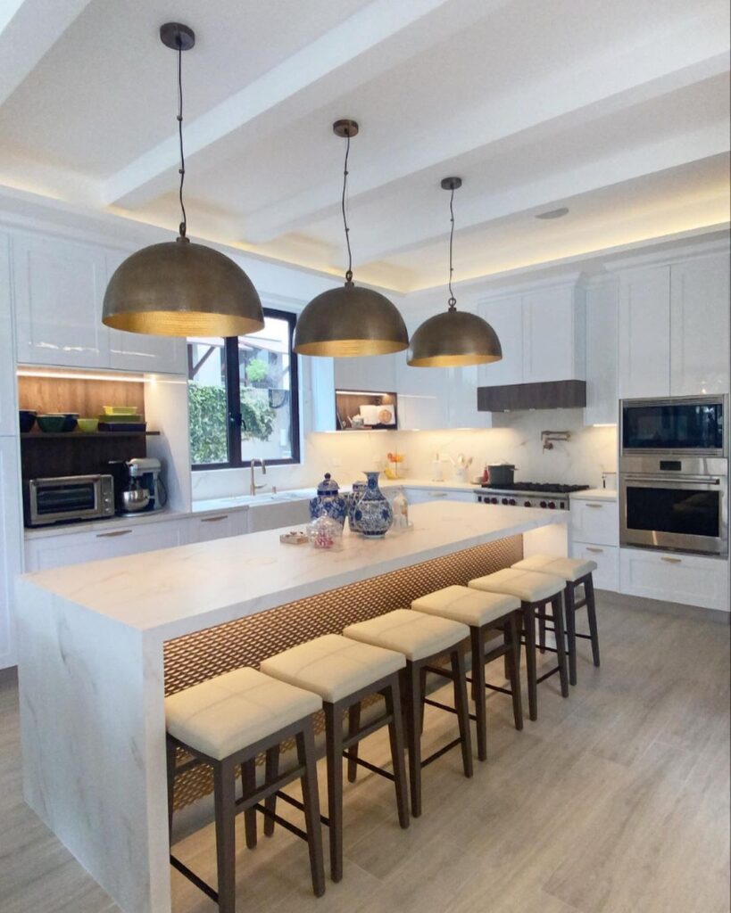 Modern white kitchen with large island dome lights and barstools