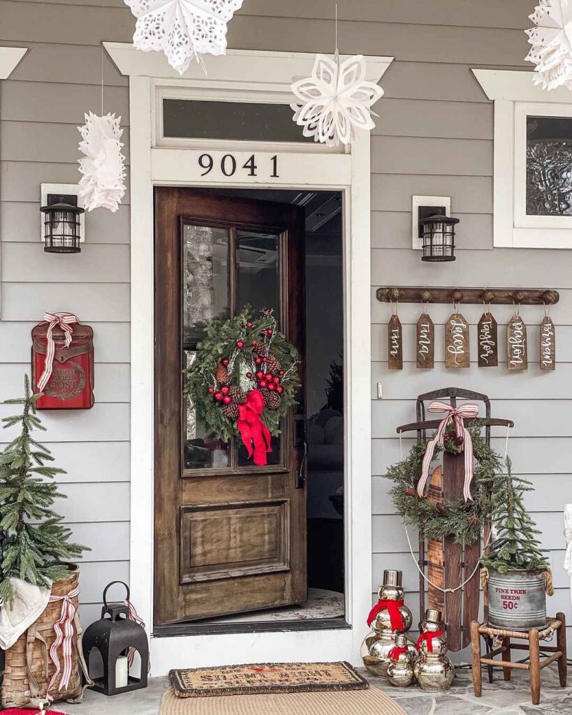 Rustic Christmas porch decor with wreath sled and snowflakes