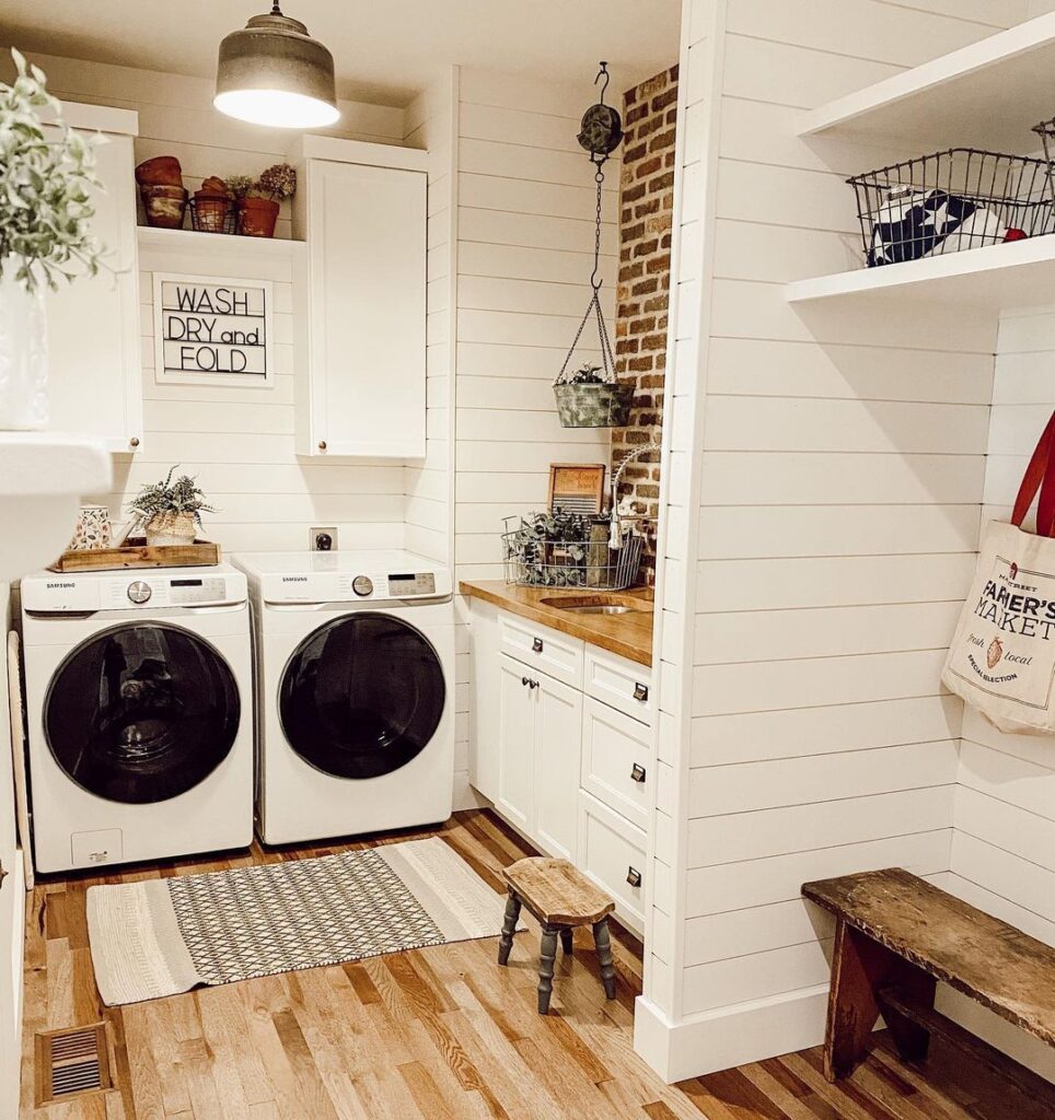 Charming white farmhouse laundry room with modern appliances and rustic decor.