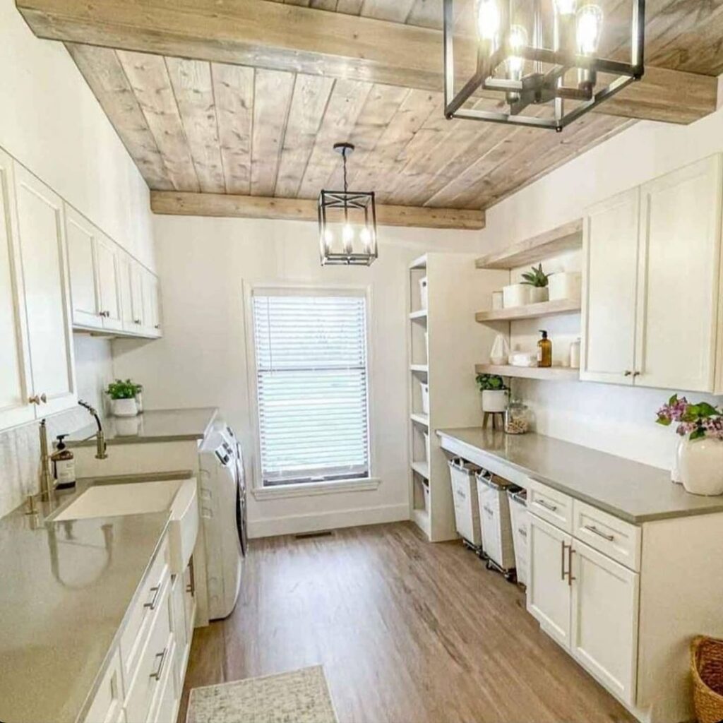 Bright laundry room with rustic wooden ceiling and white cabinets.