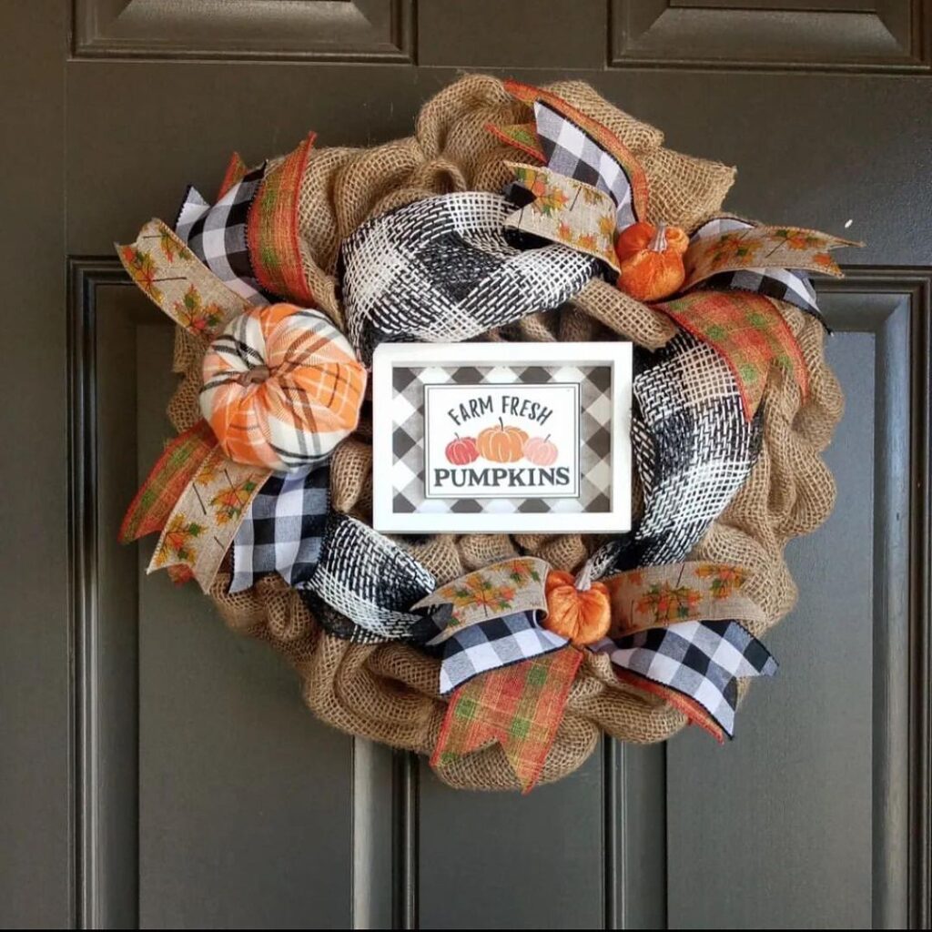 Burlap wreath with plaid ribbons pumpkins and farm sign.