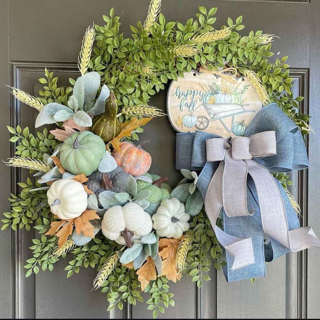 Autumn wreath with pastel pumpkins and Happy Fall sign.